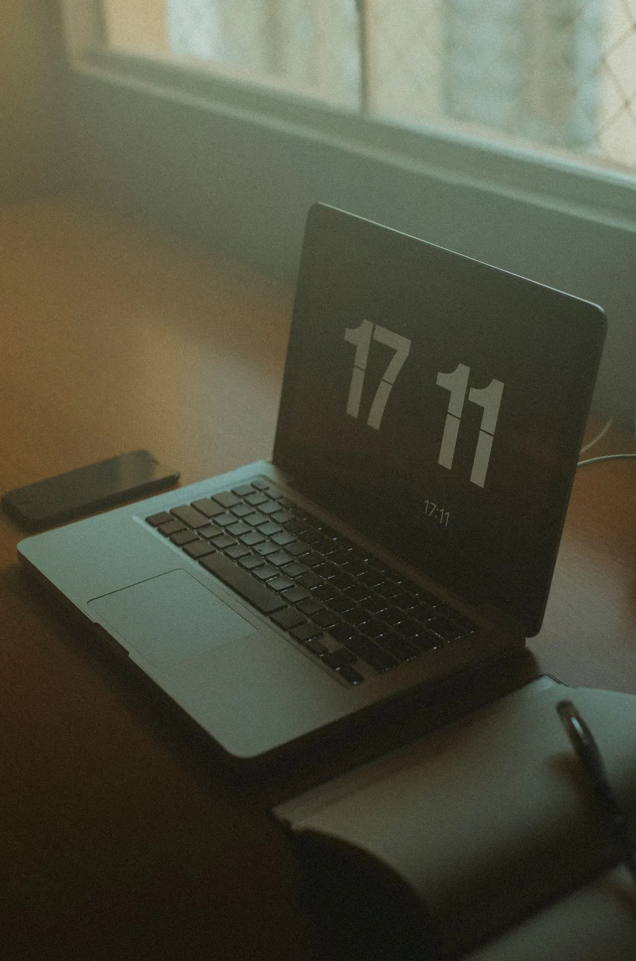Un notebook aperto su una scrivania vicino alla finestra
